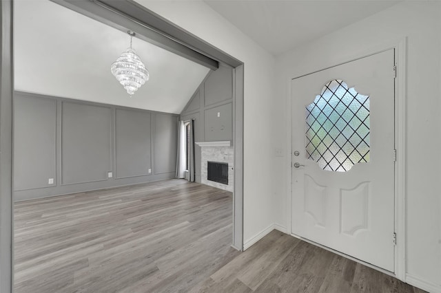 2718 Laurel Oaks Dr, Garland, TX 75044 - entrance foyer with a decorative wall, a chandelier, lofted ceiling, light wood finished floors, and a fireplace