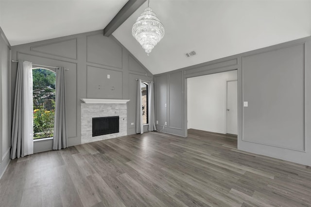 2718 Laurel Oaks Dr, Garland, TX 75044 - unfurnished living room featuring a decorative wall, a chandelier, wood finished floors, beamed ceiling, and a fireplace