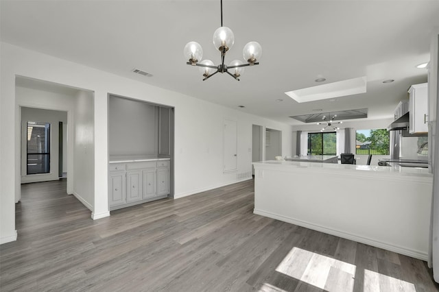 2718 Laurel Oaks Dr, Garland, TX 75044 - unfurnished living room with a chandelier, light wood finished floors, a skylight, and baseboards