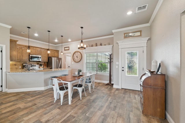 2607 Austin Dr, Granbury, TX 76048 - dining space featuring wood finished floors, a chandelier, recessed lighting, ornamental molding, and baseboards