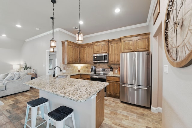 2607 Austin Dr, Granbury, TX 76048 - kitchen featuring appliances with stainless steel finishes, a peninsula, a sink, ornamental molding, and a kitchen bar