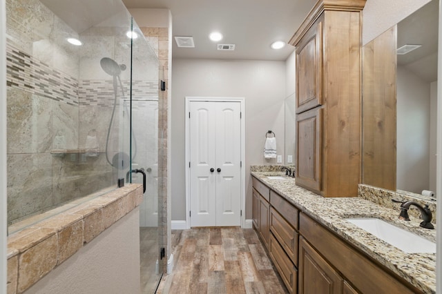 2607 Austin Dr, Granbury, TX 76048 - full bathroom with wood finished floors, a shower stall, double vanity, and recessed lighting