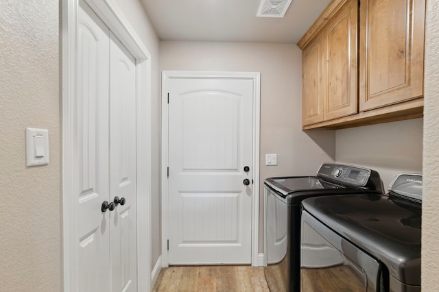 2607 Austin Dr, Granbury, TX 76048 - laundry room with washer and dryer, cabinet space, and light wood-style flooring