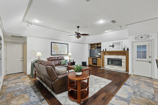 living room with ceiling fan, a tile fireplace, recessed lighting, and baseboards