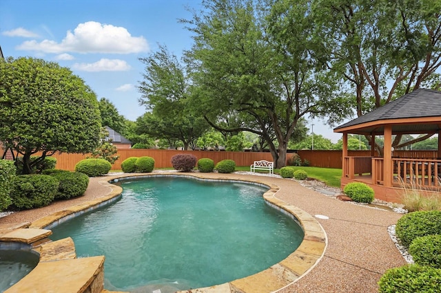 view of swimming pool with a gazebo, a fenced backyard, and a pool with connected hot tub