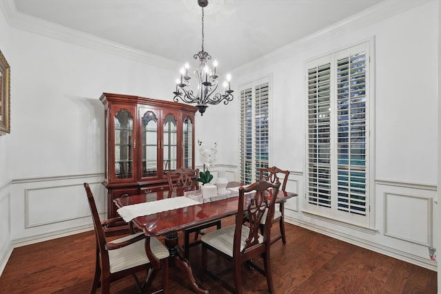 dining area with a chandelier, wood finished floors, ornamental molding, wainscoting, and a decorative wall