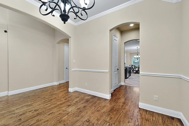 4018 Bear Creek Ct, Celina, TX 75078 - empty room featuring a chandelier, ornamental molding, arched walkways, wood finished floors, and baseboards