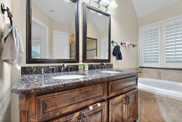 4018 Bear Creek Ct, Celina, TX 75078 - bathroom featuring lofted ceiling, a bath, and double vanity
