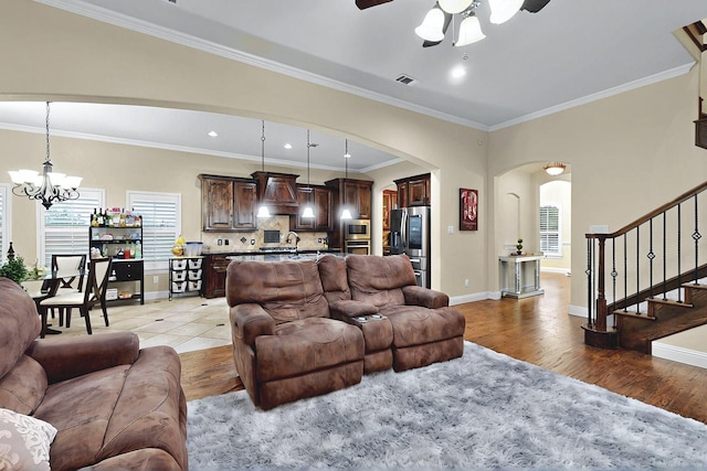 4018 Bear Creek Ct, Celina, TX 75078 - living room featuring arched walkways, a chandelier, ceiling fan, healthy amount of natural light, and crown molding
