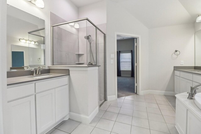 bathroom with lofted ceiling, a shower stall, tile patterned flooring, vanity, and baseboards