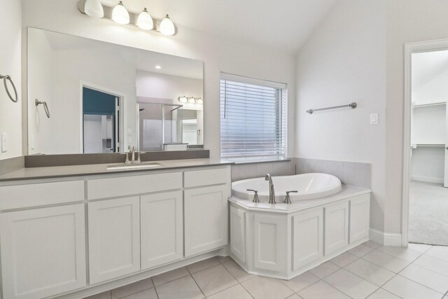 bathroom featuring tile patterned flooring, a garden tub, vanity, a shower stall, and baseboards