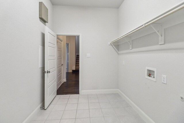 clothes washing area with hookup for a washing machine, baseboards, and light tile patterned floors