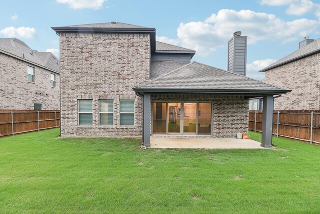 back of property with brick siding, a patio, and a shingled roof