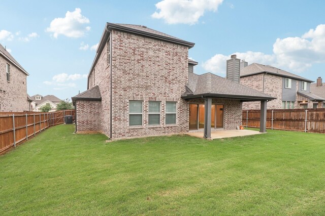 back of property featuring brick siding, a patio area, a chimney, and roof with shingles