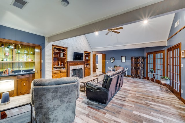 2715 Peach Tree Dr, Carrollton, TX 75006 - living area with vaulted ceiling, light wood-style floors, a fireplace, a ceiling fan, and french doors