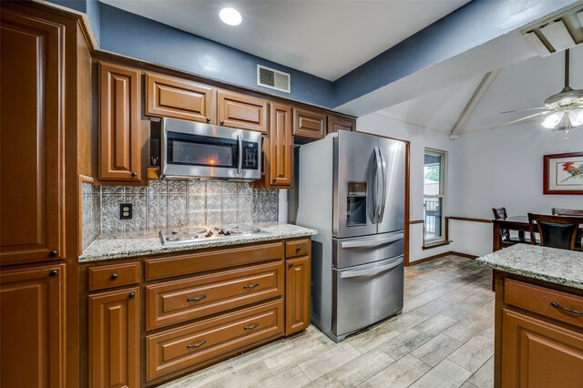 2715 Peach Tree Dr, Carrollton, TX 75006 - kitchen with appliances with stainless steel finishes, decorative backsplash, and brown cabinets
