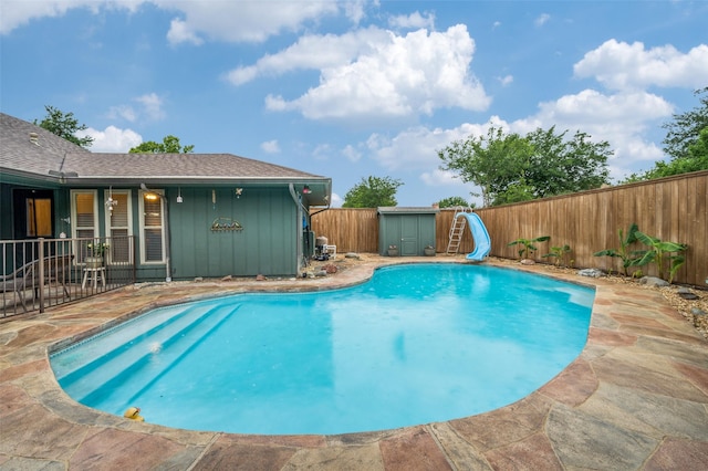 2715 Peach Tree Dr, Carrollton, TX 75006 - view of pool featuring a water slide, a fenced backyard, a patio, and a storage shed