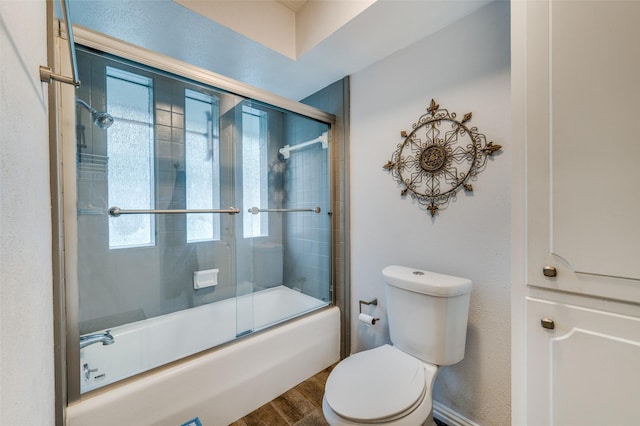 2715 Peach Tree Dr, Carrollton, TX 75006 - full bath featuring plenty of natural light, toilet, wood finished floors, and shower / bath combination with glass door