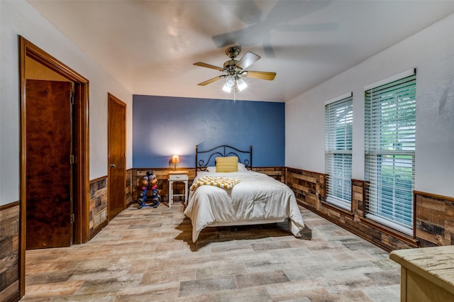 2715 Peach Tree Dr, Carrollton, TX 75006 - bedroom featuring wainscoting, wood finished floors, wood walls, and ceiling fan