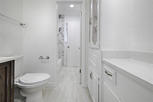 bathroom featuring toilet, vanity, and shower / washtub combination