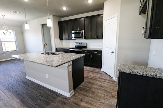 504 Lakeway Ln, Justin, TX 76247 - kitchen with stainless steel appliances, a sink, wood finish floors, baseboards, and light stone counters