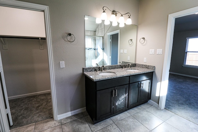 504 Lakeway Ln, Justin, TX 76247 - bathroom with a spacious closet, a stall shower, baseboards, double vanity, and tile patterned floors