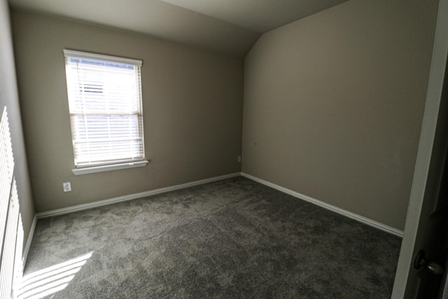 504 Lakeway Ln, Justin, TX 76247 - empty room featuring dark carpet, vaulted ceiling, and baseboards
