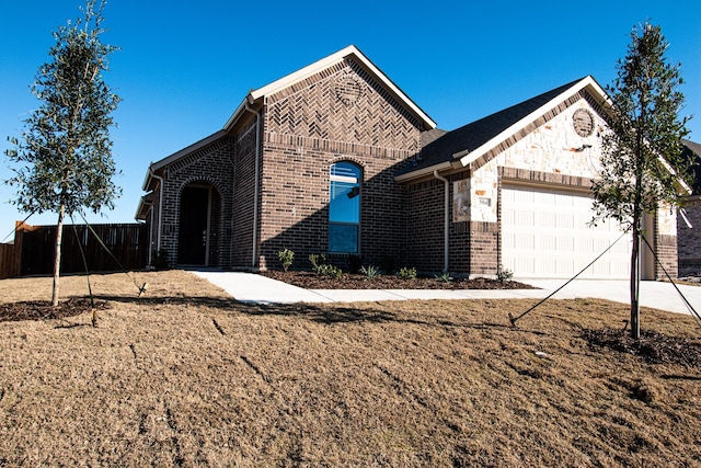 504 Lakeway Ln, Justin, TX 76247 - view of front of home with an attached garage, brick siding, driveway, and fence