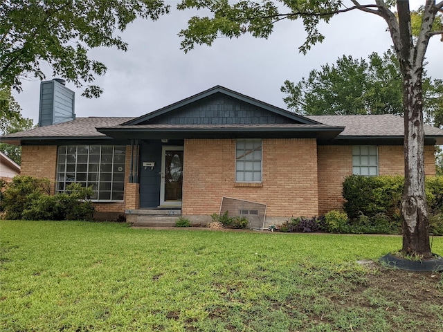 single story home with a front yard, a chimney, brick siding, and a shingled roof