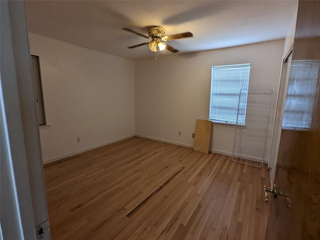 unfurnished room featuring ceiling fan, light wood finished floors, and baseboards