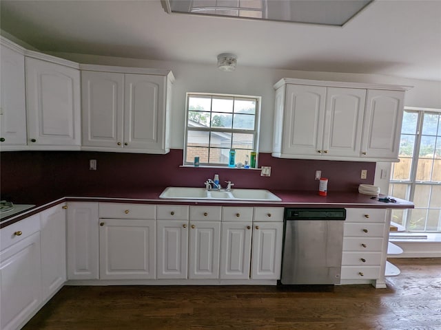 kitchen with dishwasher, a sink, dark countertops, and white cabinetry