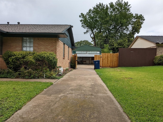 view of side of property with brick siding, a shingled roof, and driveway