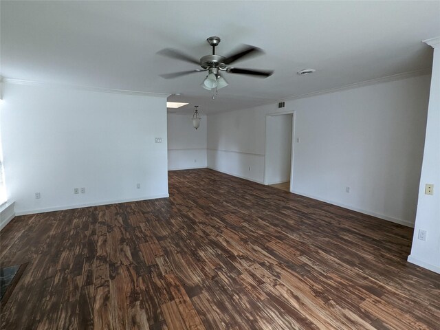 spare room featuring ornamental molding, ceiling fan, dark wood-style floors, and baseboards