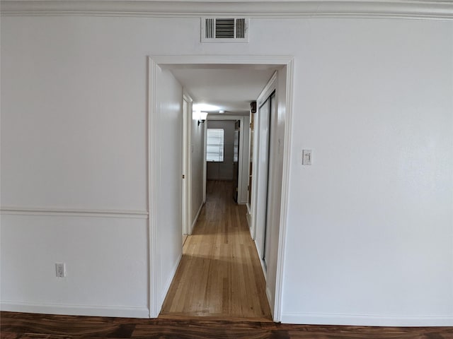 hallway with wood finished floors and baseboards