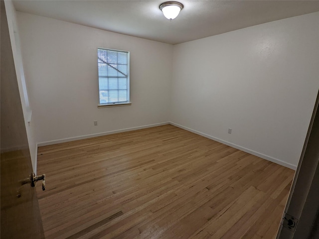 unfurnished room with light wood-style floors and baseboards