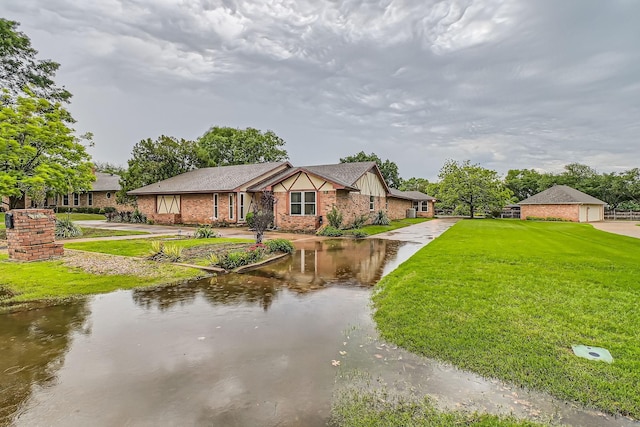 107 San Medina Ln, Joshua, TX 76058 - tudor home with a front lawn, brick siding, and a water view