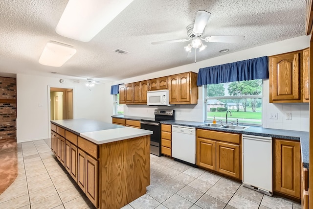 107 San Medina Ln, Joshua, TX 76058 - kitchen with white appliances, a sink, a textured ceiling, a kitchen island, and a ceiling fan