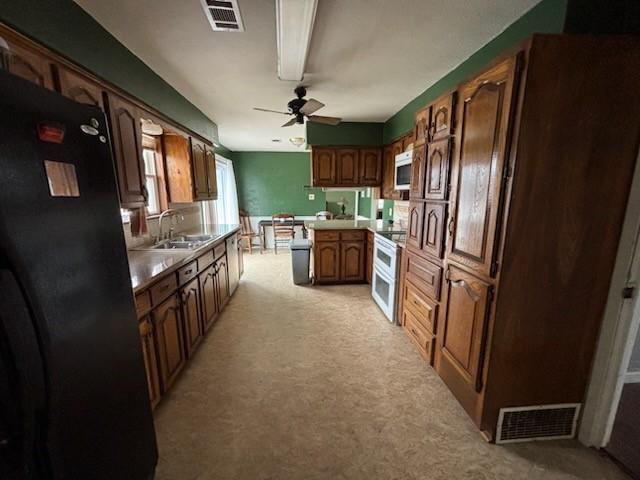 2220 N Clements St, Gainesville, TX 76240 - kitchen with light colored carpet, a sink, freestanding refrigerator, and light countertops
