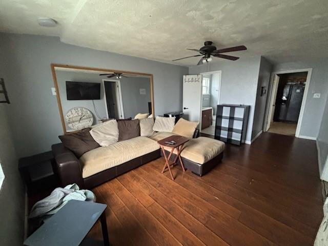 2220 N Clements St, Gainesville, TX 76240 - living room featuring a ceiling fan, wood-type flooring, baseboards, and a textured ceiling