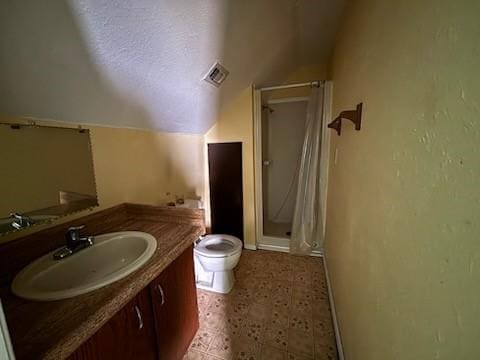 2220 N Clements St, Gainesville, TX 76240 - bathroom featuring a stall shower, toilet, vanity, vaulted ceiling, and baseboards