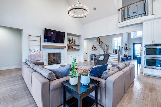 5208 Westfield Dr, Parker, TX 75002 - living area with high vaulted ceiling, stairs, a chandelier, light wood-style flooring, and built in shelves