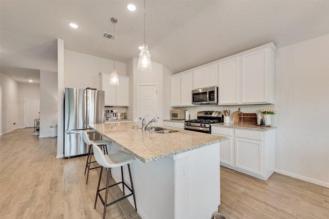 148 Greenback Trl, Fort Worth, TX 76131 - kitchen with stainless steel appliances, a sink, an island with sink, a kitchen bar, and light stone counters