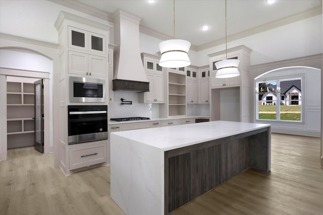 14541 Woodland Crk, Tyler, TX 75706 - kitchen with oven, arched walkways, black stovetop, stainless steel microwave, and white cabinetry
