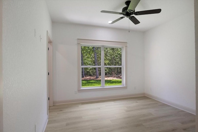 14541 Woodland Crk, Tyler, TX 75706 - empty room featuring healthy amount of natural light, light wood-style floors, a ceiling fan, and baseboards