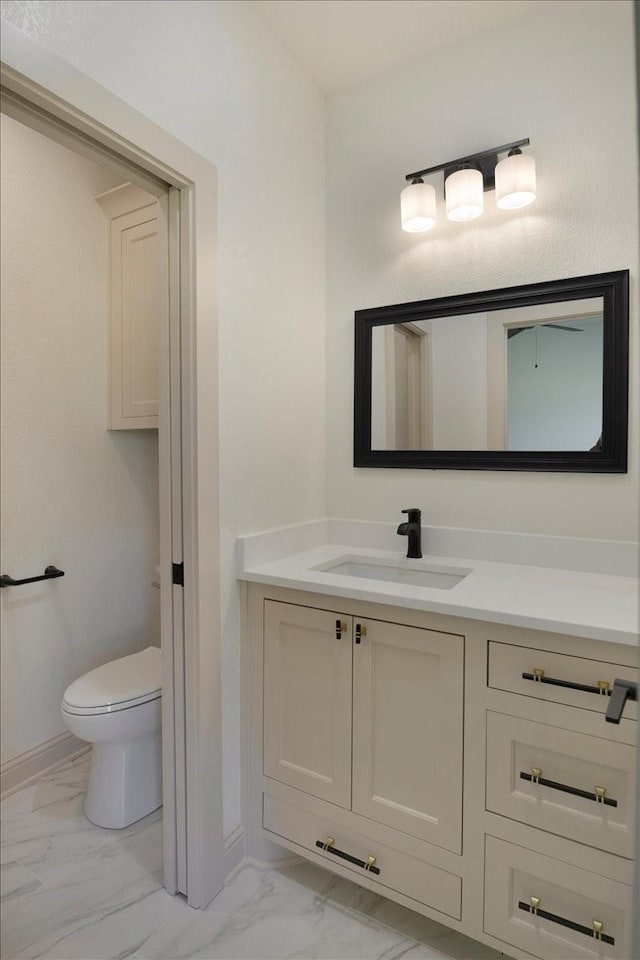 14541 Woodland Crk, Tyler, TX 75706 - bathroom featuring marble look tiles, vanity, toilet, and baseboards