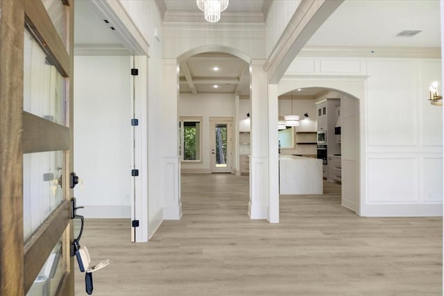 14541 Woodland Crk, Tyler, TX 75706 - entrance foyer featuring light wood-type flooring, a decorative wall, coffered ceiling, arched walkways, and beam ceiling