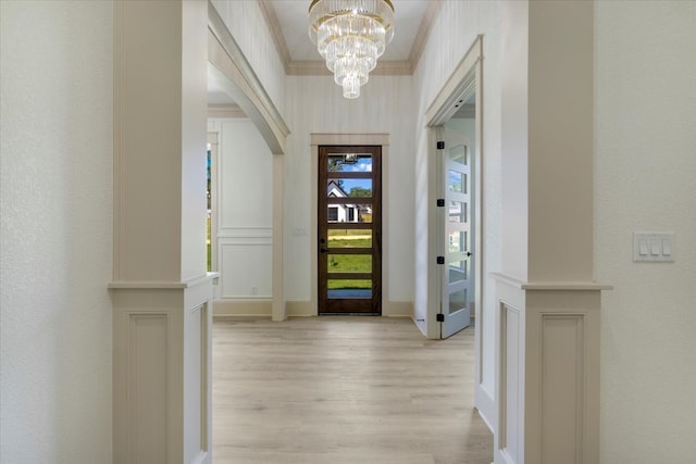 14541 Woodland Crk, Tyler, TX 75706 - foyer with light wood finished floors, a chandelier, crown molding, arched walkways, and baseboards