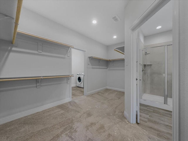 walk in closet with washer / dryer and carpet floors