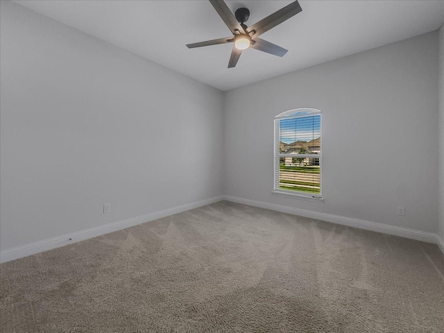unfurnished room with ceiling fan, baseboards, and carpet