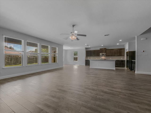 unfurnished living room featuring baseboards, ceiling fan, recessed lighting, and dark wood-type flooring